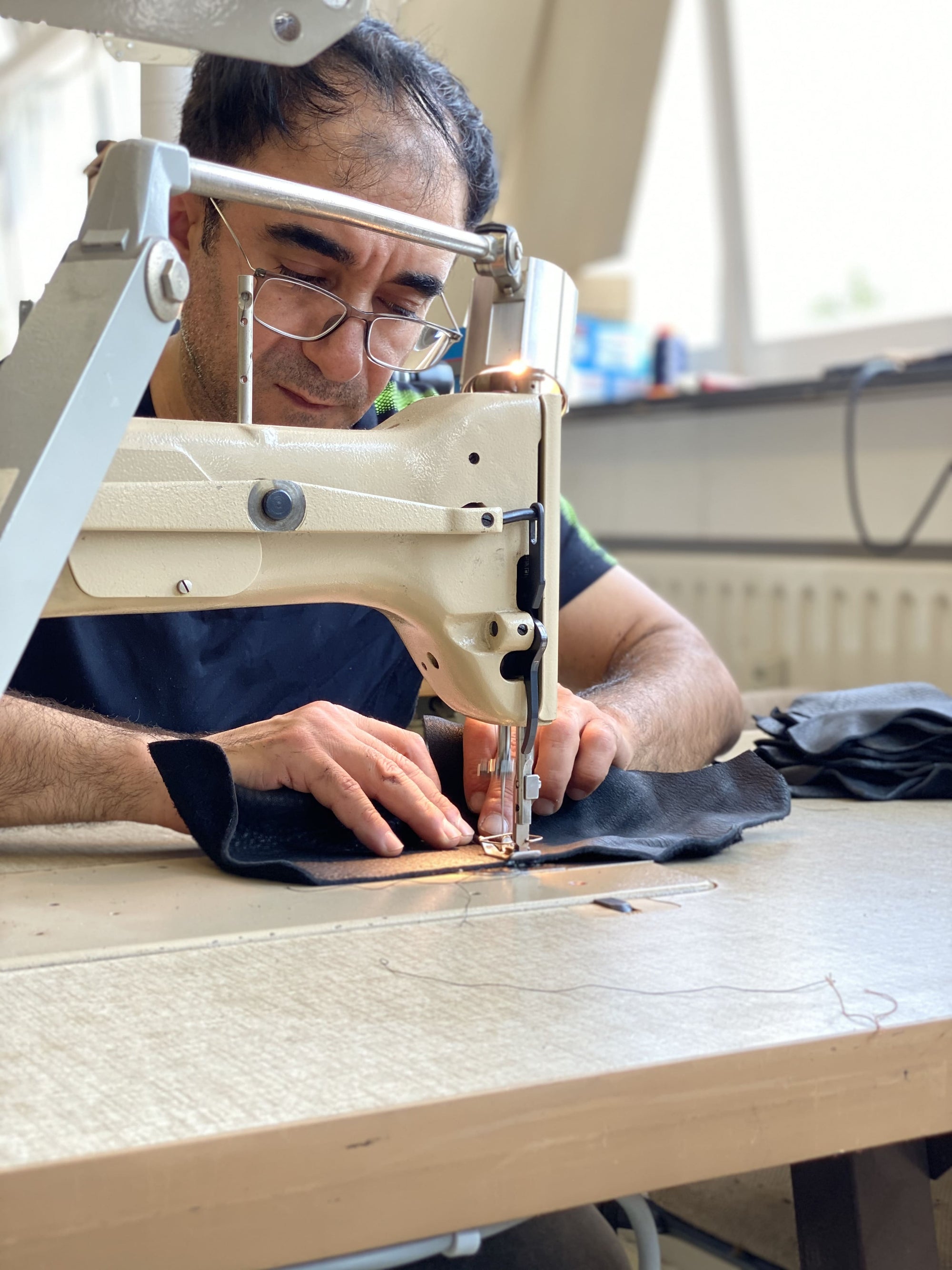 Handwerkliches vernähen des Leders in der Schuhproduktion
